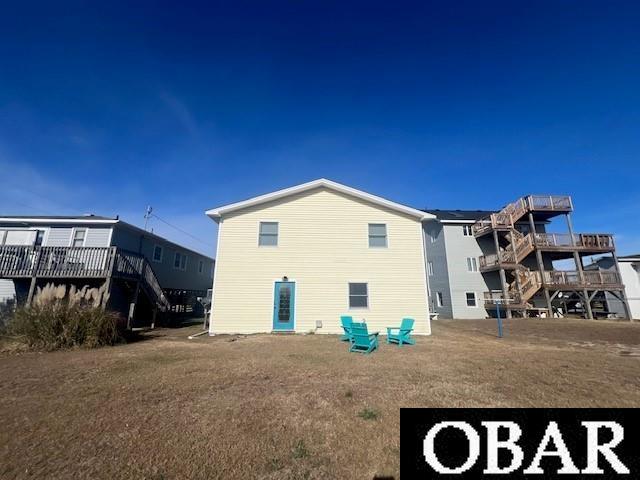 rear view of property with a deck and a lawn