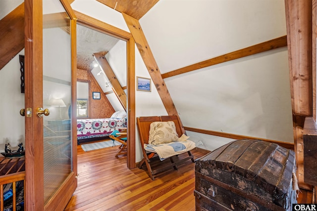 bedroom featuring lofted ceiling with beams and hardwood / wood-style floors