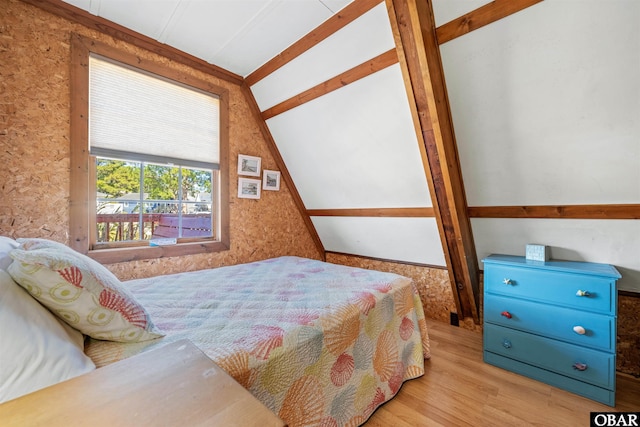 bedroom with lofted ceiling and wood finished floors