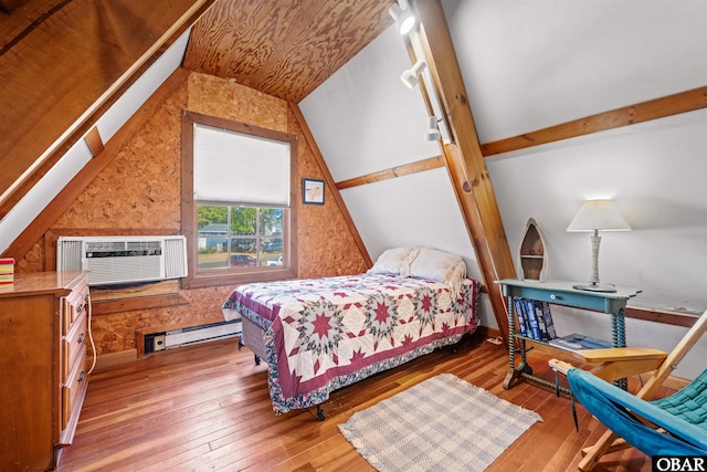 bedroom featuring a baseboard heating unit, vaulted ceiling, wood-type flooring, and a wall mounted air conditioner