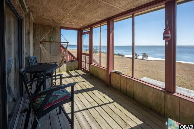 sunroom / solarium with a wealth of natural light, wood ceiling, and a water view