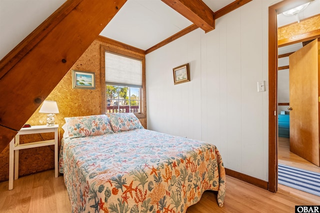 bedroom featuring beam ceiling and wood finished floors