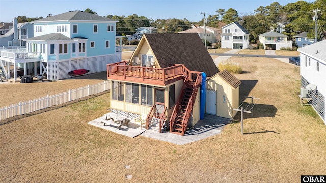 back of house with a residential view, fence, stairs, and a sunroom