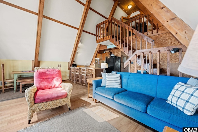 living room featuring stairway, high vaulted ceiling, and wood finished floors