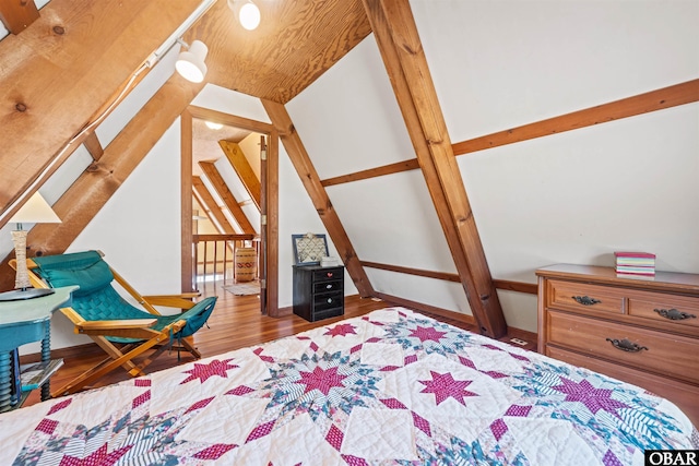 bedroom featuring vaulted ceiling, baseboards, and wood finished floors