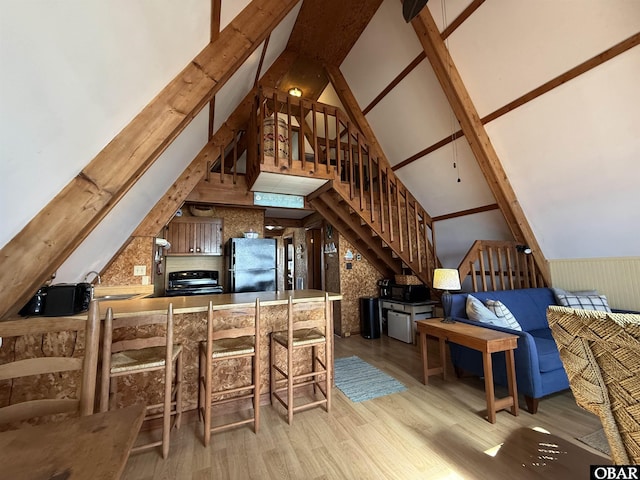 interior space with beam ceiling, a sink, high vaulted ceiling, and wood finished floors