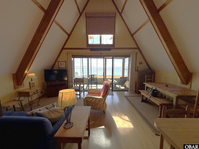 living area featuring vaulted ceiling with beams and wood finished floors