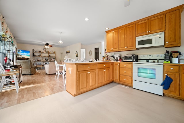 kitchen featuring ceiling fan, a peninsula, white appliances, open floor plan, and light wood-type flooring