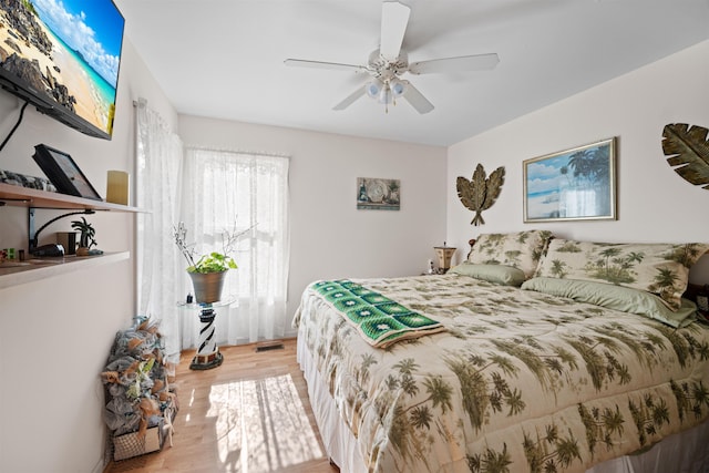 bedroom featuring light wood-style flooring, visible vents, and ceiling fan