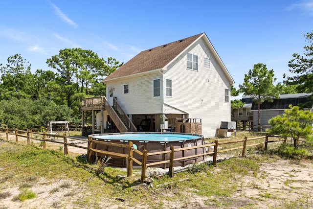 back of property featuring stairs and a deck