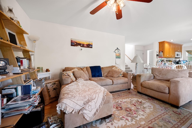 living area featuring stairs, ceiling fan, and wood finished floors