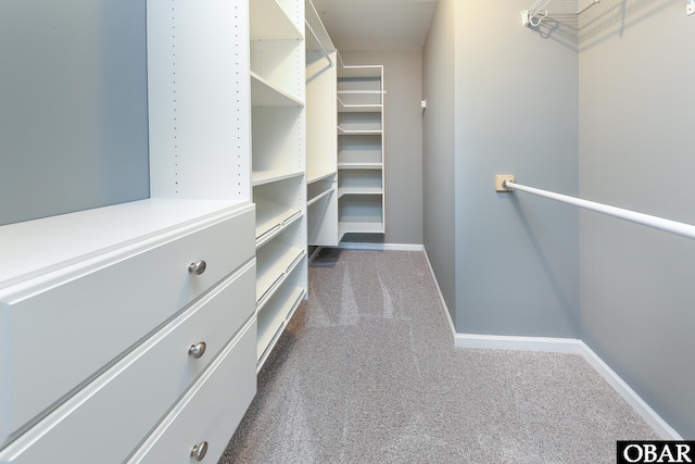 walk in closet featuring dark carpet