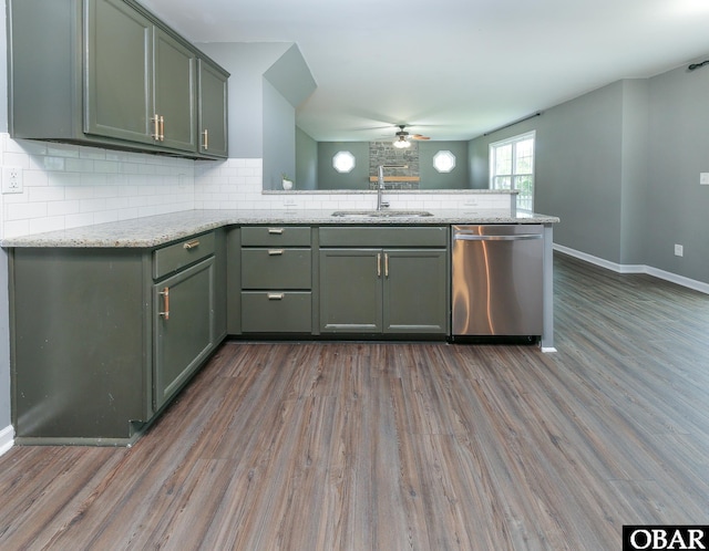 kitchen with a peninsula, a sink, tasteful backsplash, wood finished floors, and dishwasher