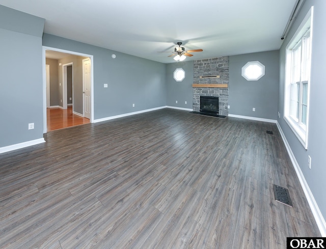 unfurnished living room featuring wood finished floors, a ceiling fan, visible vents, and a fireplace