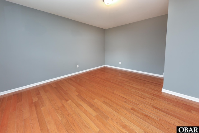 unfurnished room with baseboards and light wood-style floors