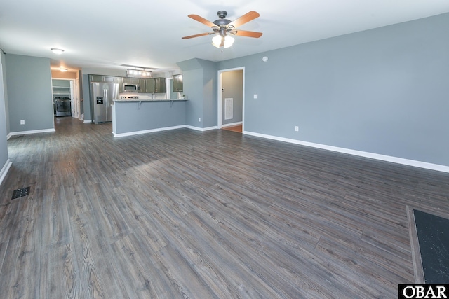 unfurnished living room featuring dark wood-type flooring, visible vents, baseboards, and ceiling fan