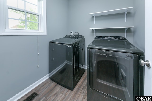 laundry area with baseboards, wood finished floors, laundry area, and independent washer and dryer