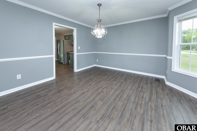 empty room with baseboards, dark wood-style floors, ornamental molding, and an inviting chandelier