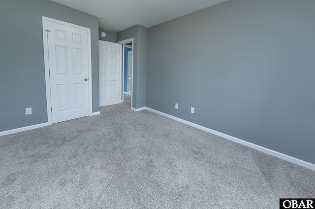 unfurnished bedroom with carpet floors and baseboards