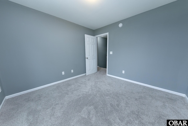 empty room featuring carpet flooring and baseboards