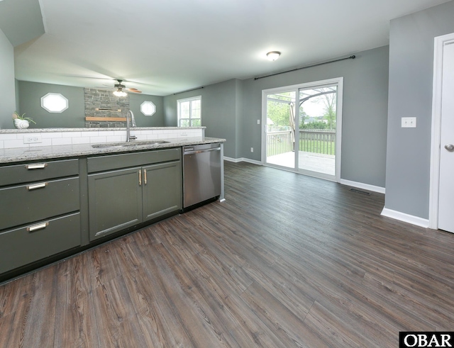 kitchen with baseboards, stainless steel dishwasher, dark wood-style flooring, and a sink