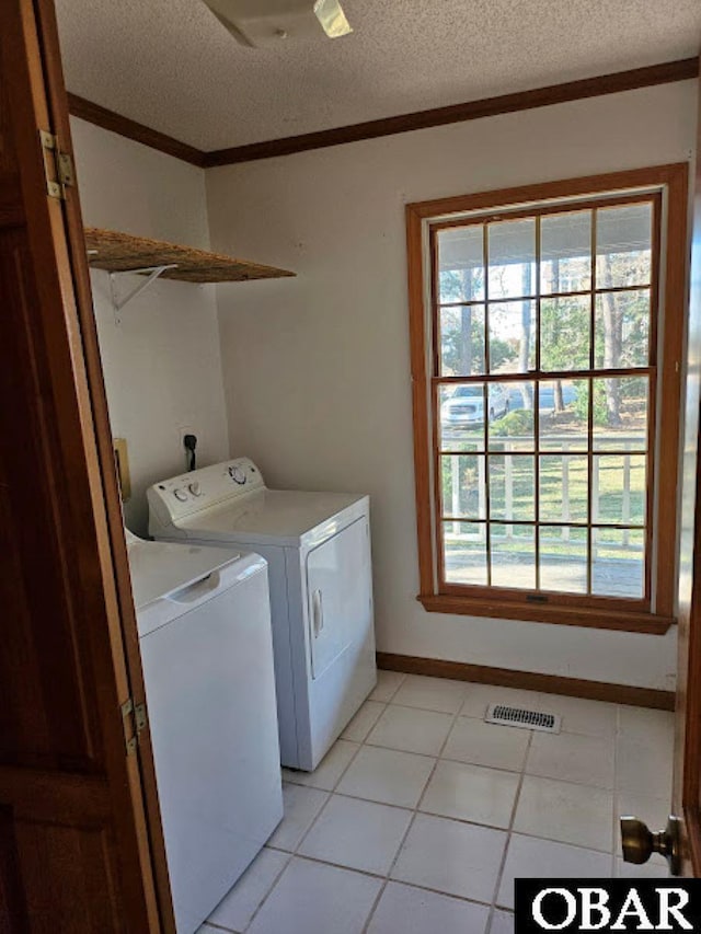 washroom featuring washer and dryer, laundry area, visible vents, and crown molding