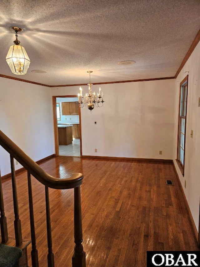 7013 Currituck Rd Lot 4, Kitty Hawk, NC 27949 - unfurnished dining area with ornamental molding, wood finished floors, a chandelier, stairway, and a textured ceiling
