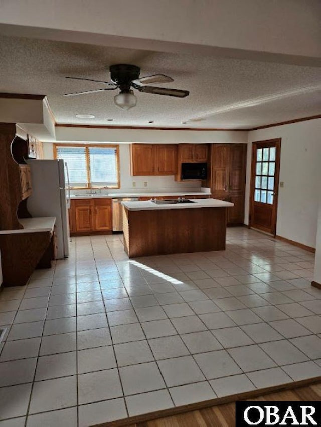 7013 Currituck Rd Lot 4, Kitty Hawk, NC 27949 - kitchen featuring a textured ceiling, a center island, light countertops, black appliances, and light tile patterned flooring