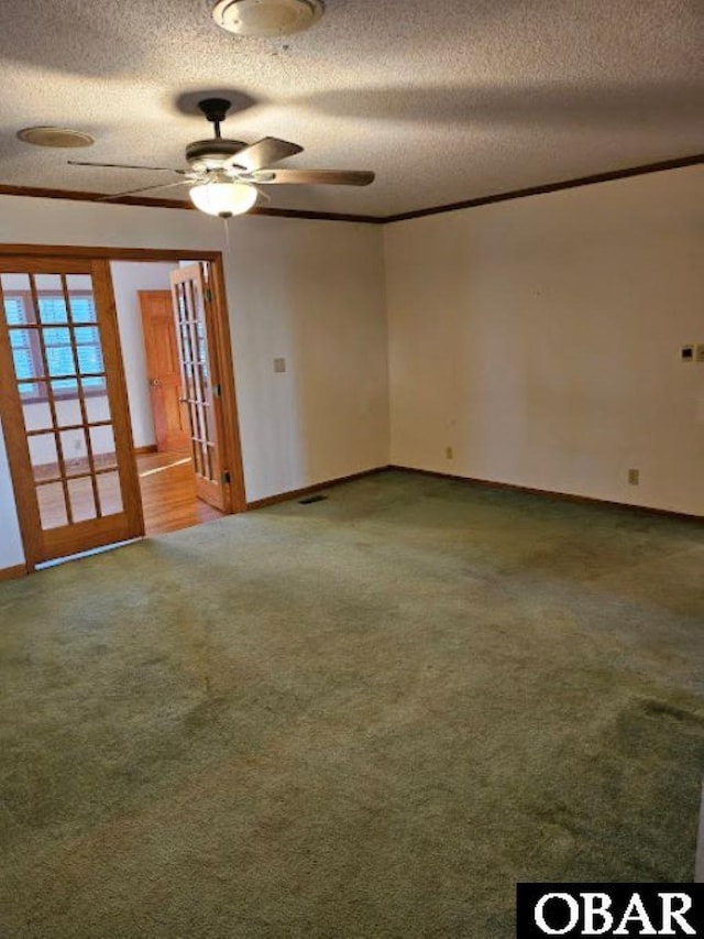 unfurnished room with carpet, ornamental molding, ceiling fan, a textured ceiling, and baseboards