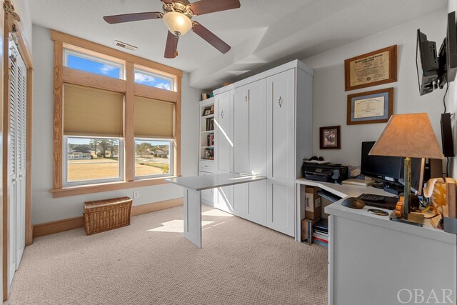 home office with baseboards, visible vents, ceiling fan, and light colored carpet