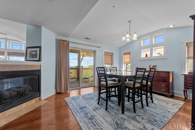 dining room with lofted ceiling, baseboards, and dark wood-style flooring