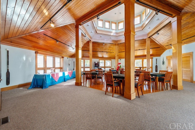 carpeted dining room with high vaulted ceiling, rail lighting, wood ceiling, and visible vents