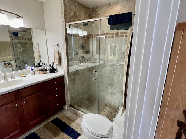 bathroom with toilet, a stall shower, and vanity