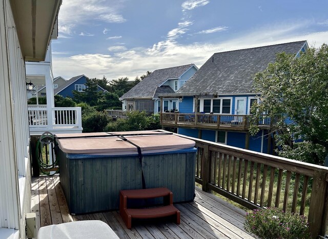 deck featuring a water view and a hot tub