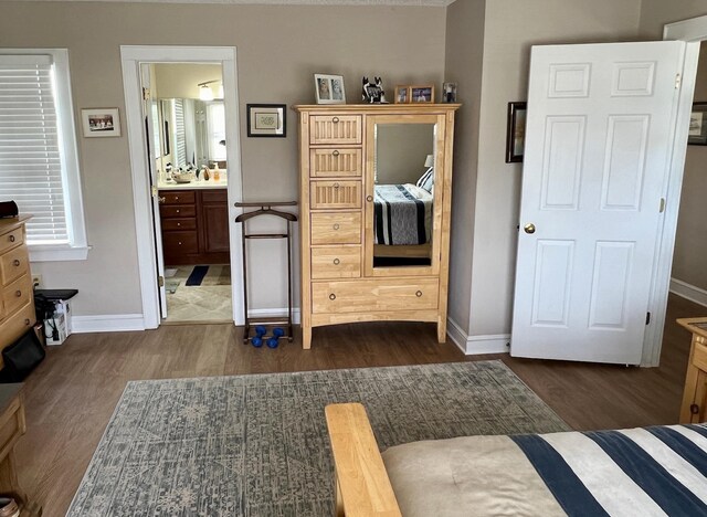 bedroom with dark wood finished floors and baseboards