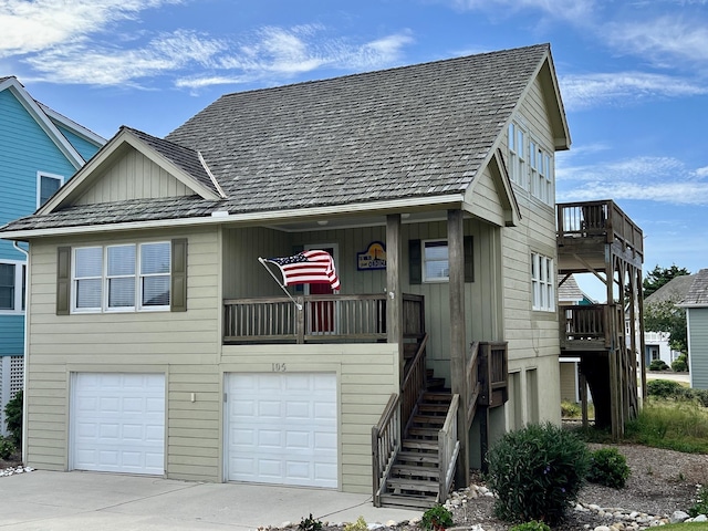 view of front facade with a balcony, a garage, driveway, stairway, and board and batten siding