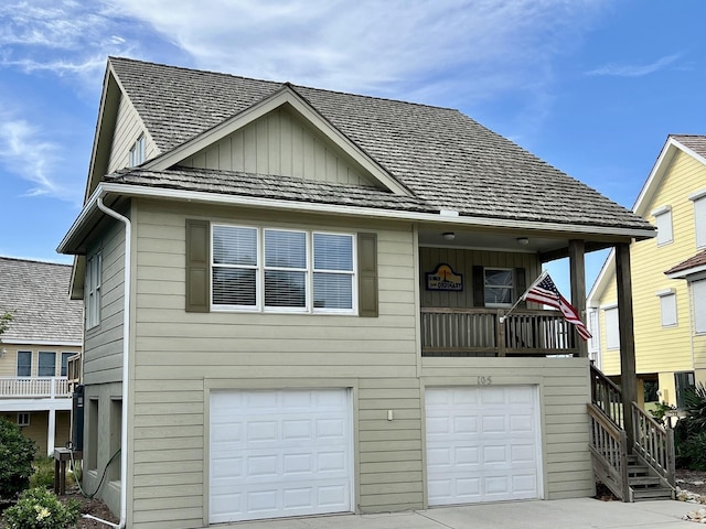 view of front of home featuring concrete driveway, stairway, board and batten siding, a balcony, and a garage