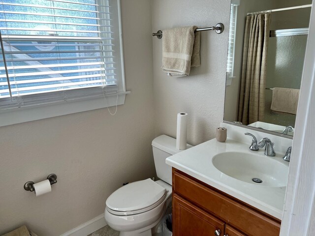 bathroom with curtained shower, baseboards, vanity, and toilet