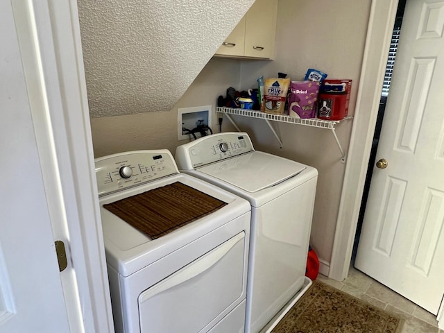 clothes washing area featuring cabinet space and independent washer and dryer