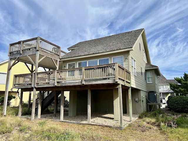 rear view of property featuring a deck and stairs