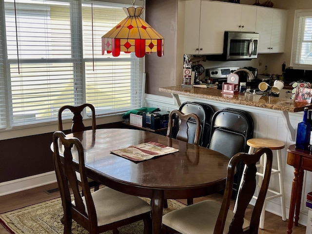 dining area featuring baseboards and wood finished floors