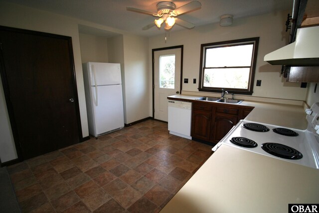 kitchen with light countertops, white appliances, a sink, and under cabinet range hood