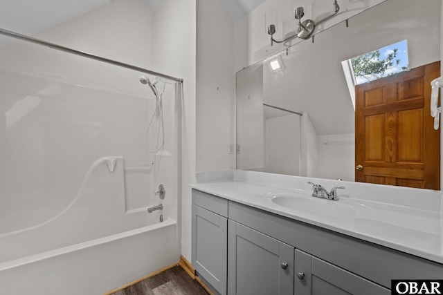 full bathroom with a skylight, shower / washtub combination, wood finished floors, and vanity