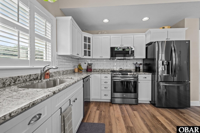 126 W Waterside Ln Lot 25, Nags Head, NC 27959 - kitchen featuring stainless steel appliances, a sink, white cabinetry, glass insert cabinets, and recessed lighting