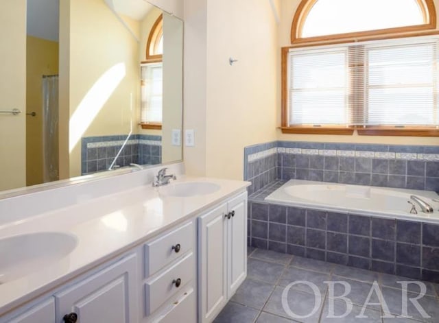 bathroom with a healthy amount of sunlight, double vanity, a sink, and tile patterned floors