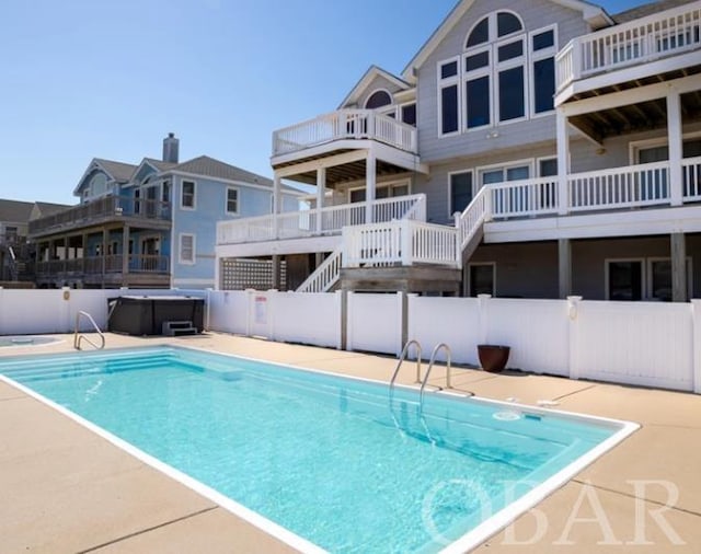 view of swimming pool with a hot tub, fence, and a fenced in pool