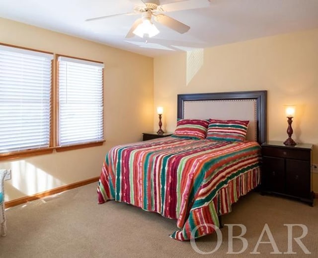 carpeted bedroom with ceiling fan and baseboards