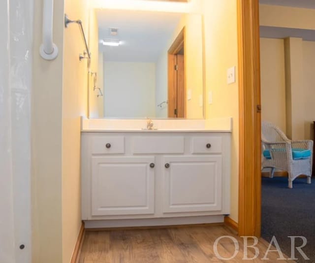 full bathroom featuring vanity, baseboards, connected bathroom, and wood finished floors