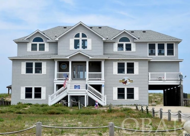 view of front of home featuring a shingled roof, stairway, a carport, and concrete driveway