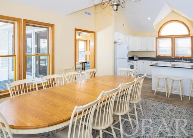 dining area featuring visible vents, lofted ceiling, dark wood-type flooring, a chandelier, and recessed lighting